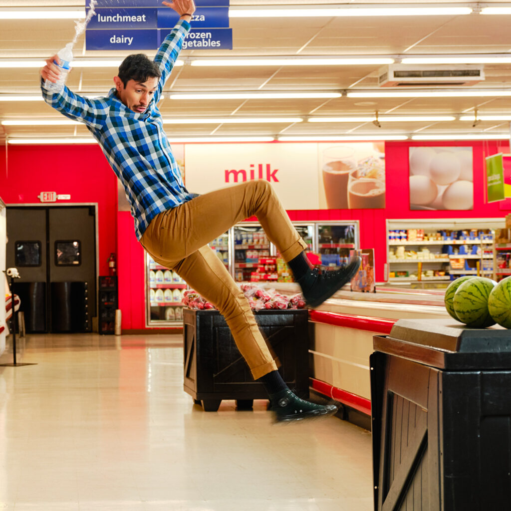 Guy high in the air at a grocery store faking a slip-and-fall.